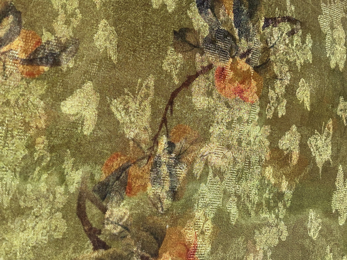 Close-up of olive-green fabric with a dense, shimmering gold floral and leafy motif, accented by muted rust-orange and dark brown details.