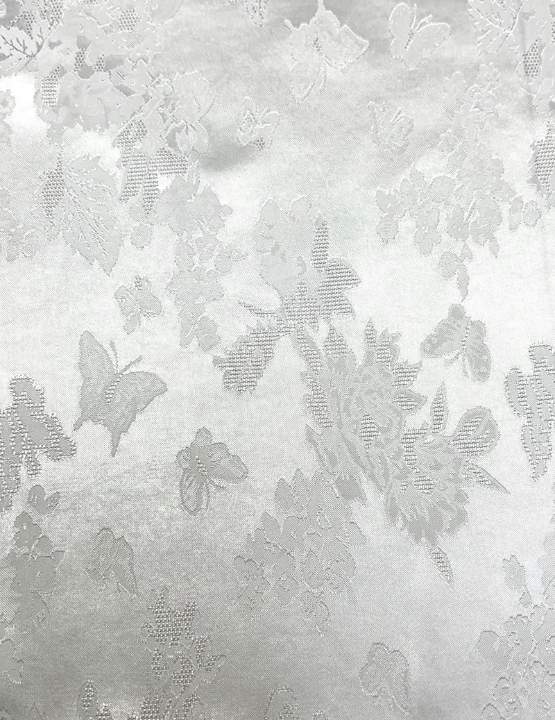 Close-up of pale gray woven fabric with a scattered floral and butterfly motif in slightly darker gray.