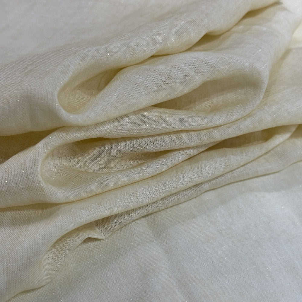 Close-up of pale ivory cloth draped in broad, curved folds, with a fine, subtly speckled surface.