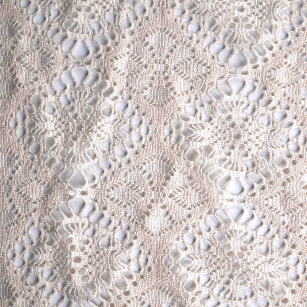 An ivory lace fabric shown flat, with a dense repeating pattern of open teardrop and circular shapes, raised textured stitching, and scalloped floral motifs.