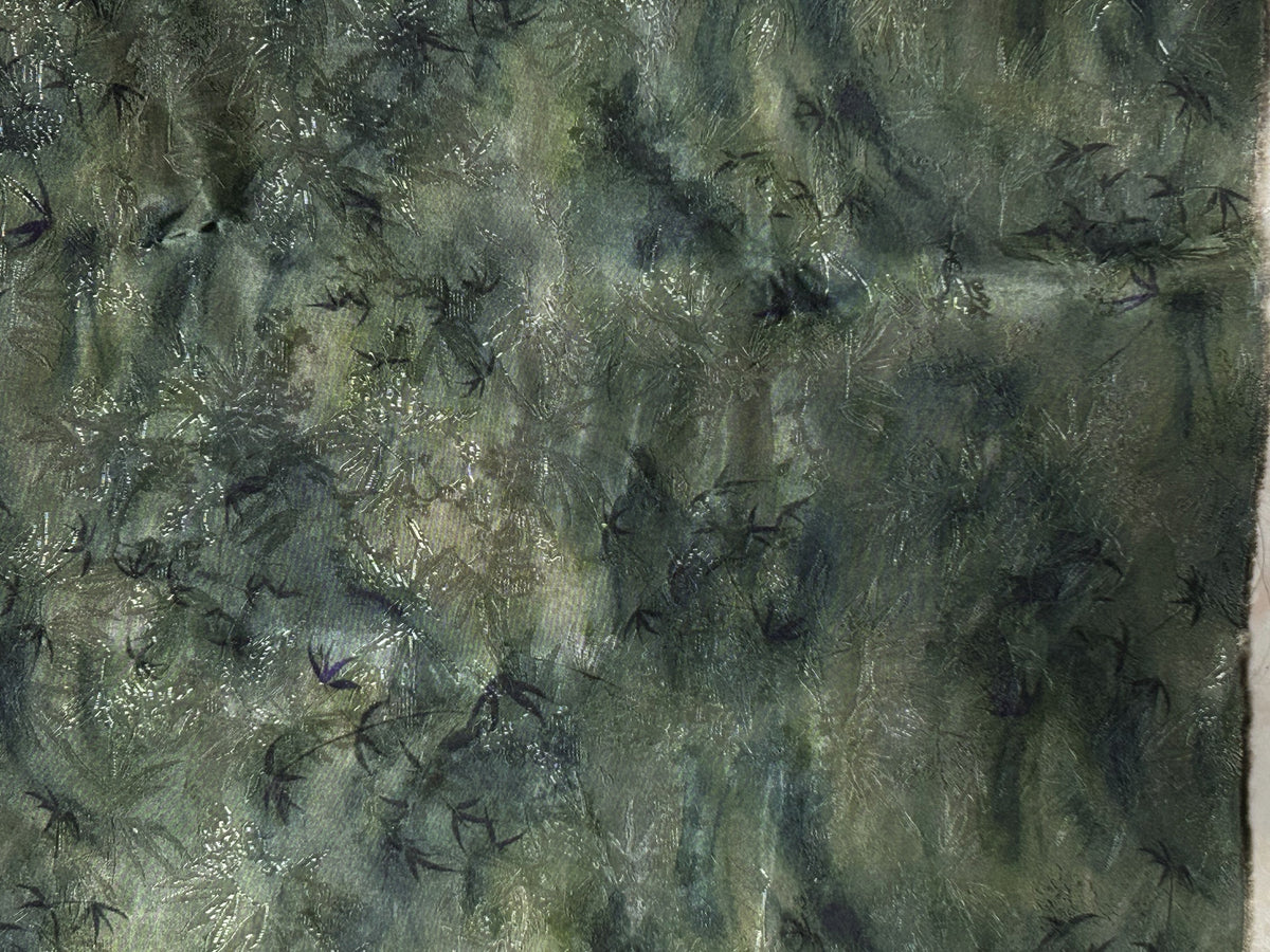 Close-up of mottled dark green and gray fabric with scattered black bird-like motifs and fine pale streaks.