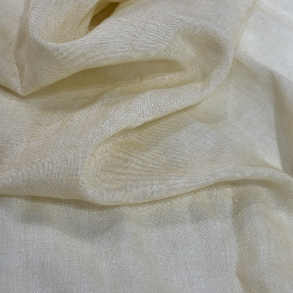 Close-up of a pale ivory cloth with a fine, plain woven appearance, draped in broad overlapping folds.