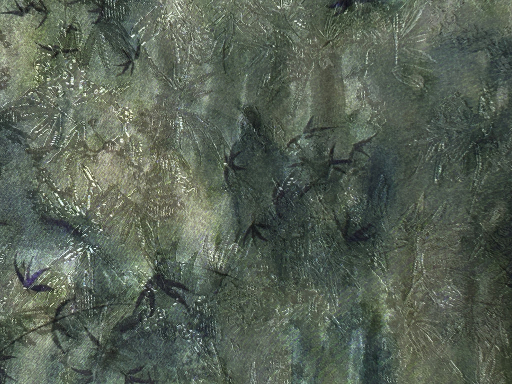 Close-up of a dark green and gray textile with an irregular mottled pattern and scattered fine, pale scratch-like lines.