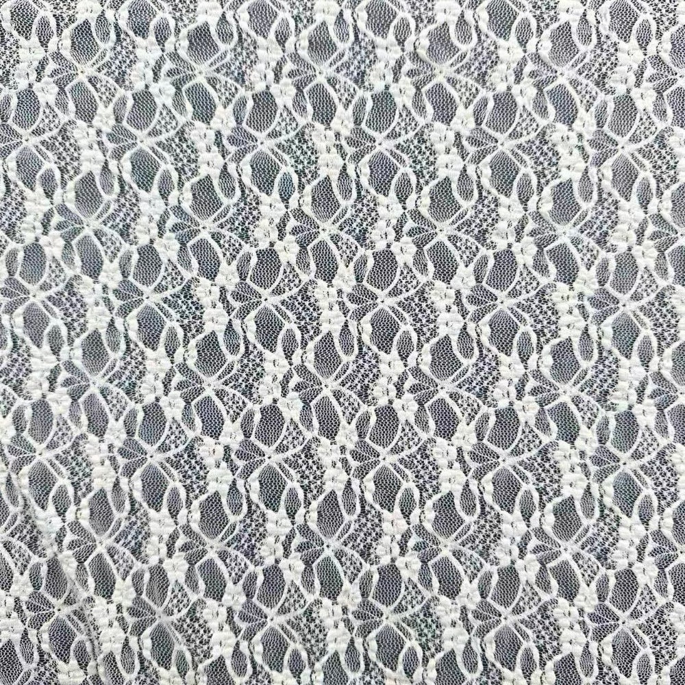 Close-up of white lace with repeating floral motifs and fine mesh openings.