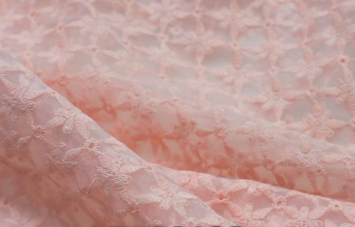 Cream embroidered fabric in folds